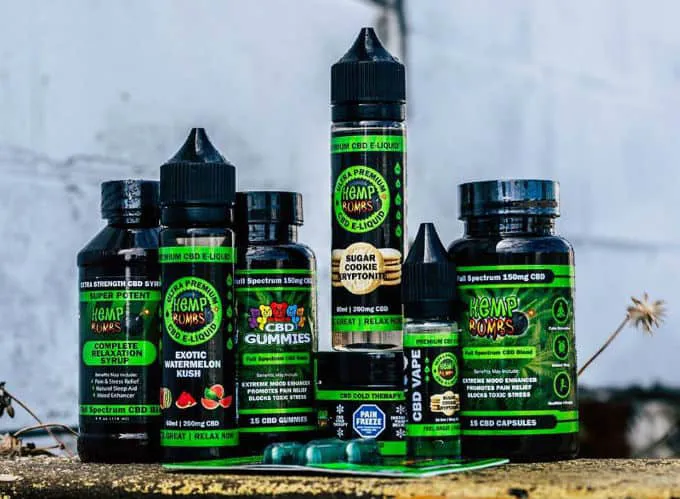 A lineup of Hemp Bombs gummies, capsules, syrup and oil bottles outdoors