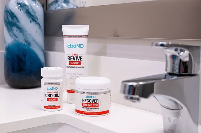 cbdMD Revive, Recover and CBD oil containers on a bathroom basin